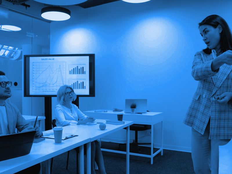 A team leader presenting results to colleagues in a modern meeting room