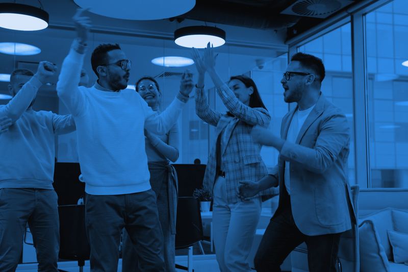 A team of young professionals celebrating a win together in the office