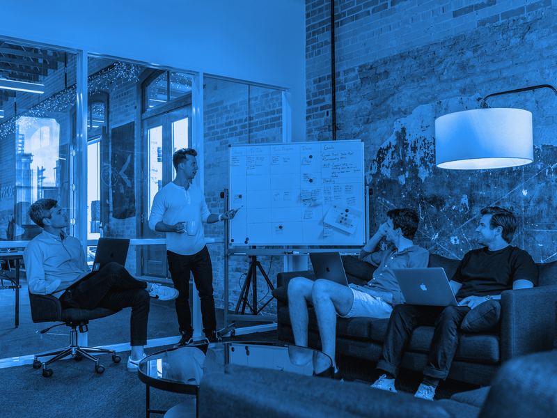 A team leader guiding a discussion at a whiteboard